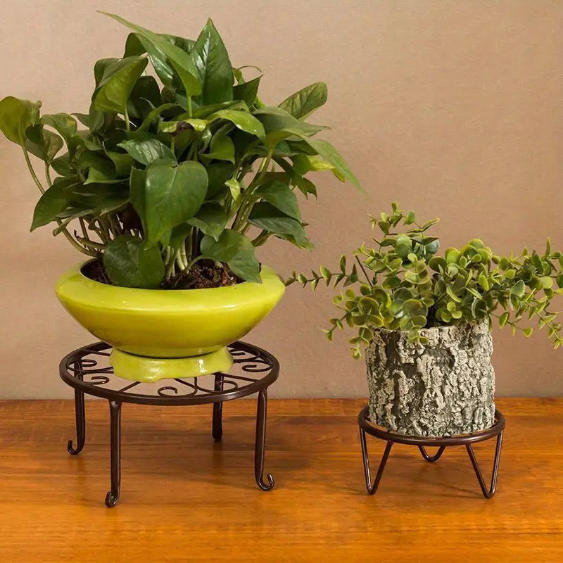 two metal plant stands, each holding a potted plant